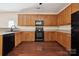 Modern kitchen with dark wood cabinets and black appliances at 1411 Ladora Dr, Charlotte, NC 28262