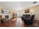 Living room with hardwood floors, fireplace, and a large TV at 1411 Ladora Dr, Charlotte, NC 28262