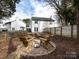 Private backyard featuring a fire pit, bridge, and a backdrop of lush trees and greenery at 1509 B Briar Creek Rd, Charlotte, NC 28205