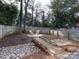 Landscaped backyard with a small wooden bridge, round seating area, and a privacy fence at 1509 Briar Creek Rd # B, Charlotte, NC 28205