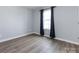 Light filled bedroom with hardwood floors and a large window with curtains at 1509 B Briar Creek Rd, Charlotte, NC 28205