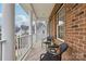 Relaxing covered porch with brick columns and wicker chairs, overlooking the neighborhood at 16341 Autumn Cove Ln, Huntersville, NC 28078