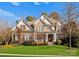 Beautiful two-story house with stone and shingle accents, a covered porch, and a lush lawn at 18621 Rollingdale Ln, Davidson, NC 28036