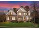 Stunning two-story home with stone and shingle exterior, welcoming porch, and manicured lawn at 18621 Rollingdale Ln, Davidson, NC 28036