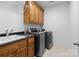 Functional laundry room with washer, dryer, and wood cabinets at 18621 Rollingdale Ln, Davidson, NC 28036