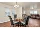 The dining room has a glass-top table, seating for four, and lots of natural light at 208 Lakewood Ave, Charlotte, NC 28208