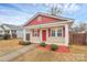 Charming single-story home with a red and beige exterior, and well-manicured landscaping at 208 Lakewood Ave, Charlotte, NC 28208