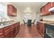 A kitchen with cherry cabinets and laminate countertops looks onto a dining and living area at 208 Lakewood Ave, Charlotte, NC 28208