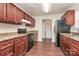 A kitchen with cherry cabinets, laminate countertops, an electric range and a stainless steel refrigerator at 208 Lakewood Ave, Charlotte, NC 28208