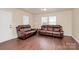 Comfortable living room features multiple leather sofas, wood floors, and bright natural lighting at 208 Lakewood Ave, Charlotte, NC 28208