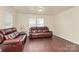 Spacious living room features leather sofas, wood floors, and bright natural lighting at 208 Lakewood Ave, Charlotte, NC 28208