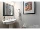 Small powder room with pedestal sink and framed artwork at 211 Harbour Place Dr, Davidson, NC 28036