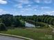 Arial view of a serene pond and park area with walking path, offering a peaceful community setting at 211 Harbour Place Dr, Davidson, NC 28036