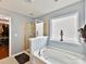 Bright bathroom features a glass-enclosed shower, soaking tub, and a window for natural light and ventilation at 3020 Sewee Ln, Waxhaw, NC 28173