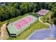 Aerial view of two well-maintained tennis courts surrounded by lush greenery at 3020 Sewee Ln, Waxhaw, NC 28173