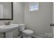 Small half bathroom with pedestal sink and dark floor at 638 Sagecroft Ln, Indian Trail, NC 28079