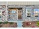 Townhome's front entrance with stonework, a brown door, and landscaping at 638 Sagecroft Ln, Indian Trail, NC 28079