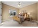 Bedroom with wooden bed frame and window overlooking backyard at 7005 Shadow Rock Ct, Matthews, NC 28104