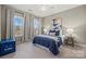 Bedroom with blue bedding, two windows and side table at 7005 Shadow Rock Ct, Matthews, NC 28104