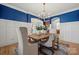 Elegant dining room with wainscoting, hardwood floors, and a wood table at 7005 Shadow Rock Ct, Matthews, NC 28104