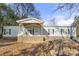 Light blue mobile home with covered porch and rocking chairs at 7933 Cherry Point Dr, Denver, NC 28037