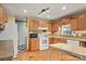 Galley kitchen with oak cabinets and white appliances at 7933 Cherry Point Dr, Denver, NC 28037