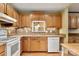 Kitchen with oak cabinets, white appliances, and tin backsplash at 7933 Cherry Point Dr, Denver, NC 28037