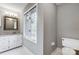 Clean bathroom with white vanity, granite countertop, and window at 9435 Squirrel Hollow Ln, Charlotte, NC 28720