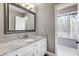 Bathroom with granite countertop, white cabinets, and large mirror at 9435 Squirrel Hollow Ln, Charlotte, NC 28720