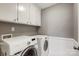 Laundry room with Samsung washer and dryer, and cabinets above at 9435 Squirrel Hollow Ln, Charlotte, NC 28720