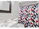 Clean bathroom with white vanity, shower, and geometric patterned curtain at 1028 White Ln, Gastonia, NC 28052