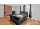 Bedroom with brick fireplace, hardwood floors, and a black sleigh bed at 1028 White Ln, Gastonia, NC 28052
