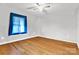 Bright bedroom with hardwood floors and a window with blue curtains at 1028 White Ln, Gastonia, NC 28052