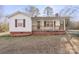White house with red accents, covered porch, and grassy yard at 1028 White Ln, Gastonia, NC 28052