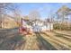 White house with red brick base and deck, in a wooded area at 1028 White Ln, Gastonia, NC 28052