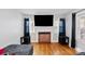 Living room with hardwood floors, fireplace, and large TV at 1028 White Ln, Gastonia, NC 28052