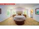Bright bedroom features neutral decor, an upholstered headboard, two windows and an ensuite bathroom at 11127 Cardinal Creek Ave, Charlotte, NC 28215