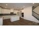 Open kitchen with white cabinets, central island, stainless steel appliances and hardwood floors at 1136 Yellow Springs Dr, Huntersville, NC 28078
