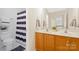 Well-lit bathroom with a double vanity, tile flooring, and modern fixtures at 11805 Farnborough Rd, Huntersville, NC 28078