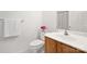 This bathroom features a white toilet, a wooden cabinet with white sink, and light pink flower decor at 11805 Farnborough Rd, Huntersville, NC 28078
