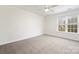 Cozy bedroom with carpeted floors, neutral walls, and a bright window at 11805 Farnborough Rd, Huntersville, NC 28078