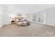 Spacious main bedroom with large windows, a tray ceiling, and neutral decor at 11805 Farnborough Rd, Huntersville, NC 28078