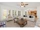 A bright, open-plan living room boasts many windows, a ceiling fan, and neutral decor at 11805 Farnborough Rd, Huntersville, NC 28078