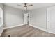 Bedroom with wood-look floors, ceiling fan and access to another room at 1515 Sugarcane Ln, Gastonia, NC 28056