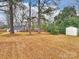 Fenced backyard with mature trees and storage shed at 2013 Tyvola Rd, Charlotte, NC 28210