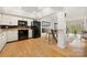 Modern kitchen with black appliances, white cabinetry, and a breakfast bar overlooking the living space at 204 Riverview Ter, Lake Wylie, SC 29710