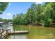 Picturesque lake scene featuring a wooden dock with boats, lush greenery, and calm waters at 204 Riverview Ter, Lake Wylie, SC 29710