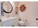 Clean bathroom with white vanity, toilet, and decorative wreath at 2137 Jack Wilson Rd, Shelby, NC 28150