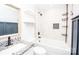 This is a bathroom featuring a shower-tub combo, white tile, granite sink and black fixtures at 5020 Foster Rd, Cleveland, NC 27013