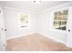 Cozy bedroom featuring carpet flooring, neutral paint, and natural light from two windows at 5020 Foster Rd, Cleveland, NC 27013